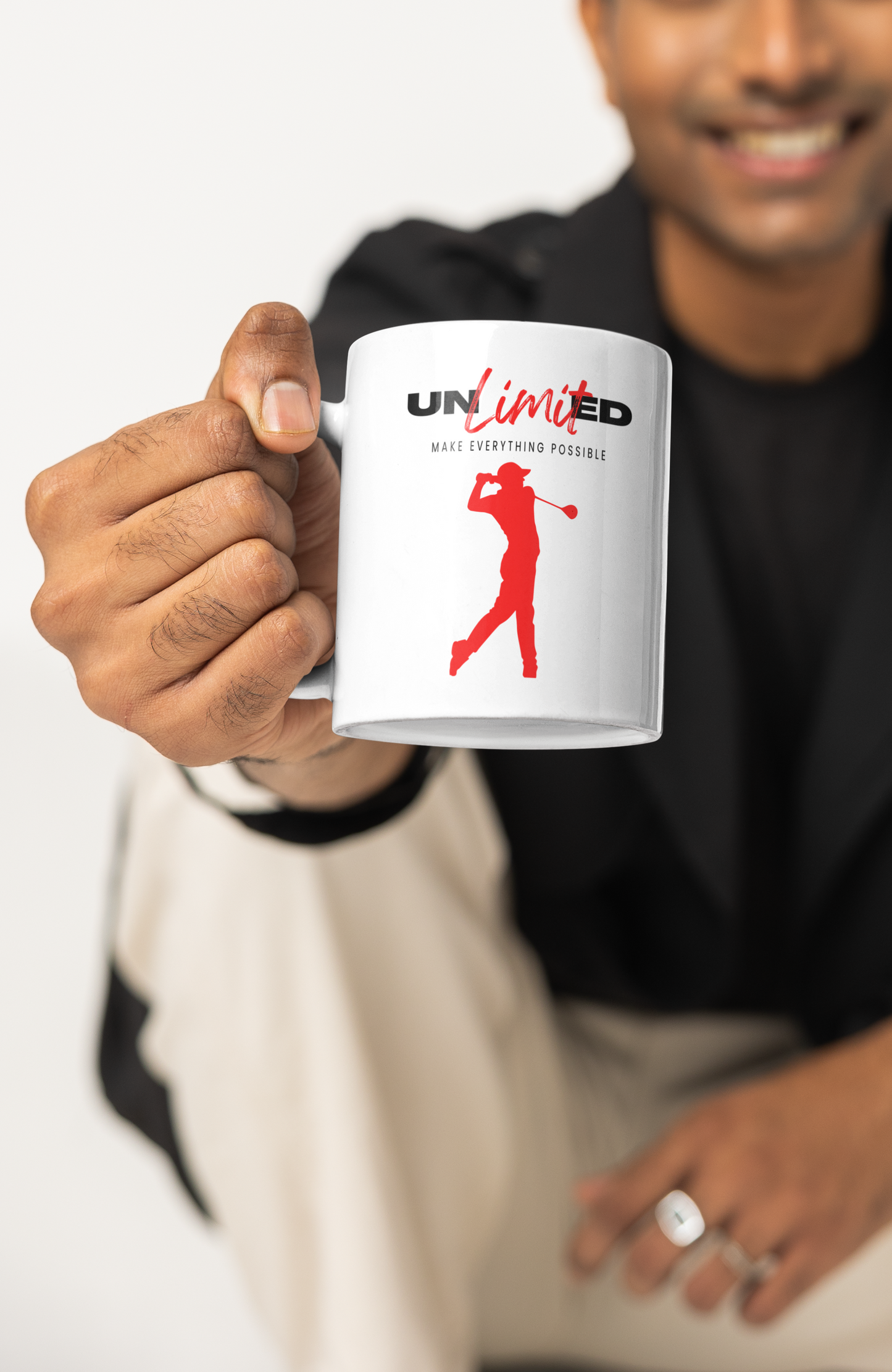 Person holding a mug with 'UNLIMTED' logo featuring a silhouette of a person.